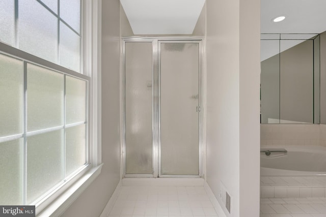 full bathroom with a stall shower, baseboards, and plenty of natural light