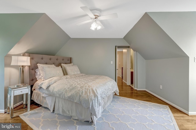 bedroom featuring vaulted ceiling, baseboards, a ceiling fan, and wood finished floors