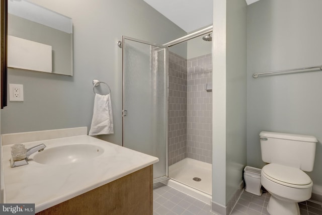 full bathroom with toilet, a stall shower, baseboards, tile patterned flooring, and vanity