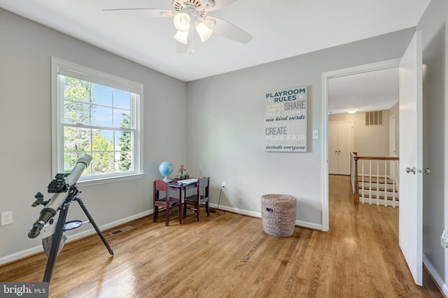 interior space featuring visible vents, wood finished floors, baseboards, and ceiling fan