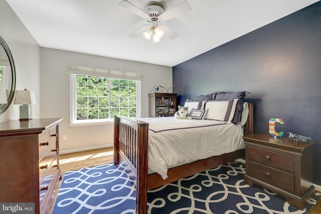 bedroom featuring a ceiling fan, wood finished floors, and baseboards