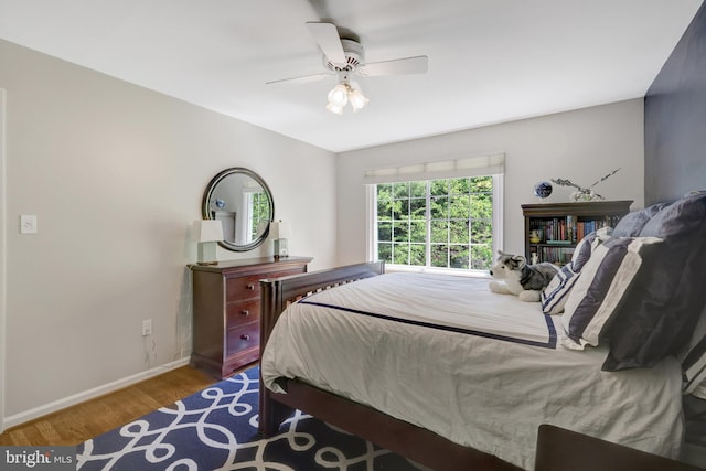 bedroom featuring baseboards, ceiling fan, and wood finished floors