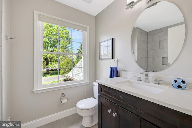 bathroom featuring baseboards, tile patterned flooring, vanity, and toilet