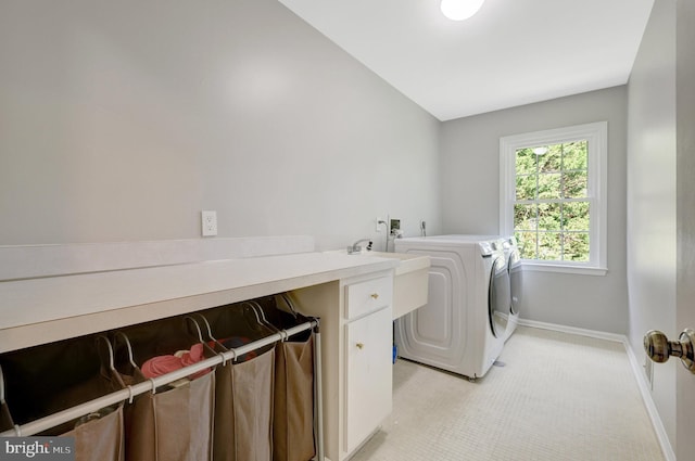 washroom featuring a sink, independent washer and dryer, laundry area, light carpet, and baseboards
