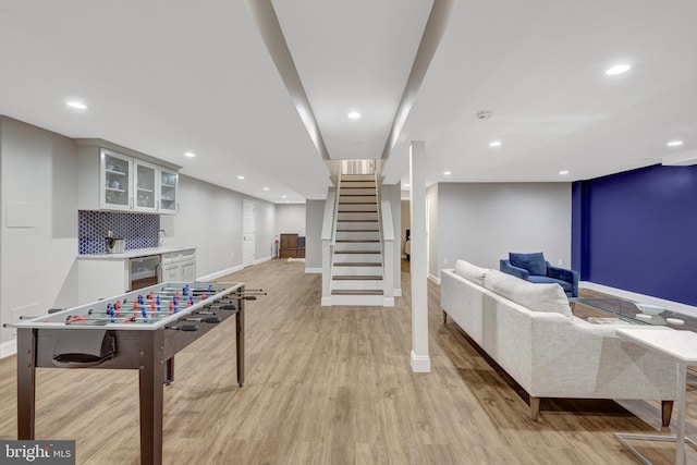 playroom featuring recessed lighting, baseboards, light wood-style flooring, and wine cooler