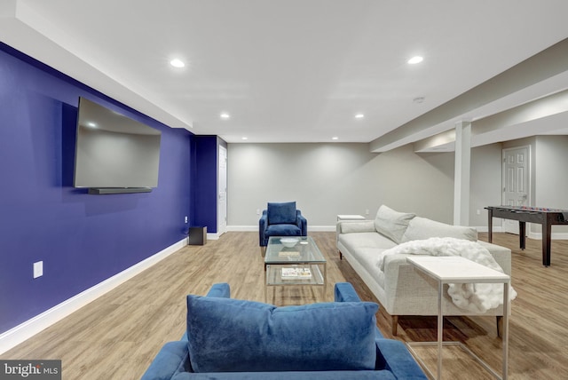 living area with baseboards, light wood-type flooring, and recessed lighting