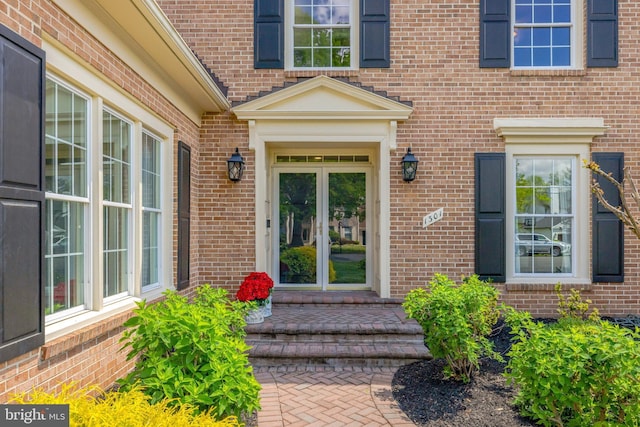 entrance to property featuring french doors and brick siding
