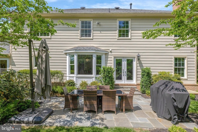back of property featuring a patio area, outdoor dining area, and french doors