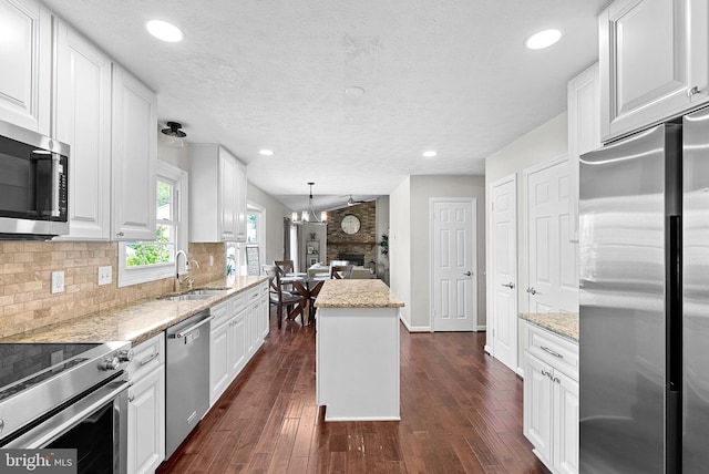 kitchen featuring white cabinets, tasteful backsplash, a sink, stainless steel appliances, and dark wood-type flooring