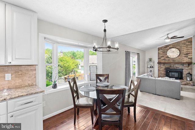 dining space with baseboards, lofted ceiling, dark wood-style floors, and a healthy amount of sunlight