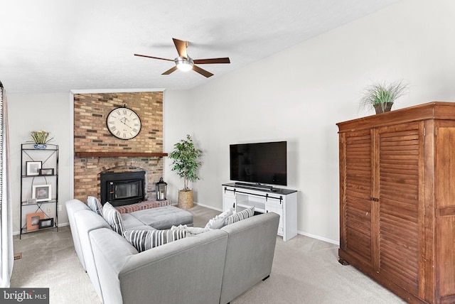 living room featuring a ceiling fan, baseboards, light carpet, and a fireplace