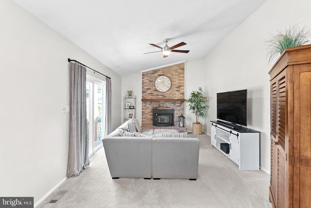 living area featuring a brick fireplace, a ceiling fan, vaulted ceiling, and light carpet