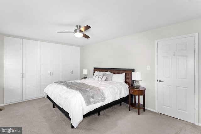bedroom featuring ceiling fan, light carpet, and baseboards