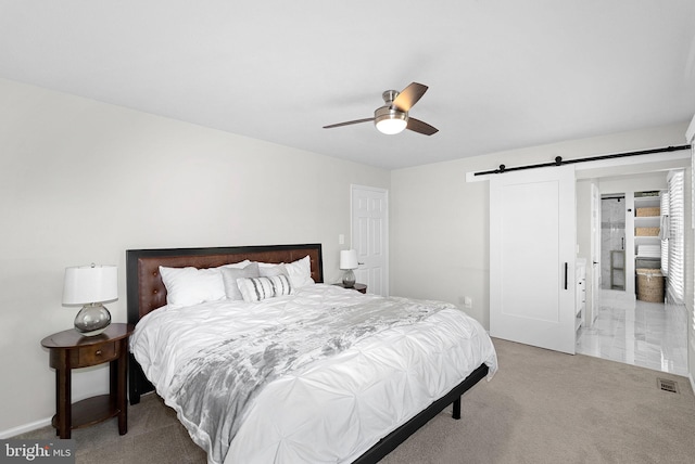 bedroom with ceiling fan, carpet flooring, a barn door, and visible vents