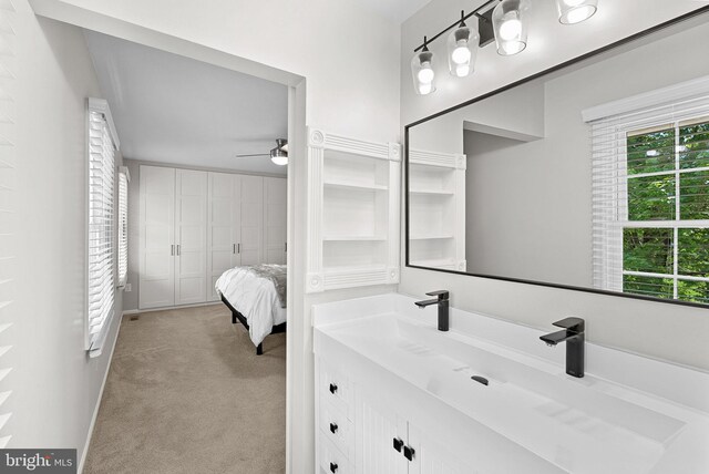 bathroom with baseboards, ceiling fan, and vanity