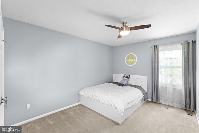 bedroom with baseboards, a ceiling fan, and light colored carpet