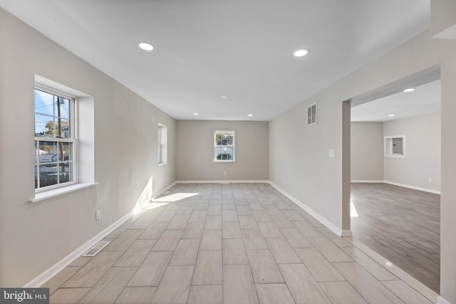 spare room with recessed lighting, light wood-style floors, and baseboards