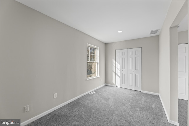 unfurnished bedroom featuring carpet floors, baseboards, a closet, and recessed lighting