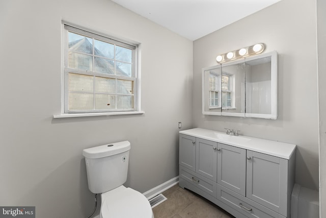 bathroom with toilet, vanity, and baseboards