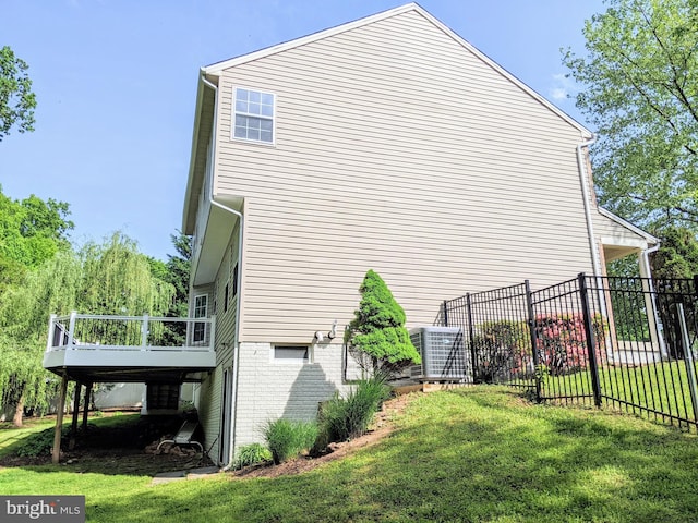 view of home's exterior with a lawn, fence, central air condition unit, and a wooden deck