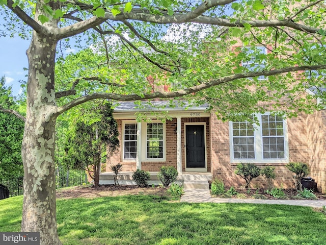 view of front of home featuring brick siding and a front lawn