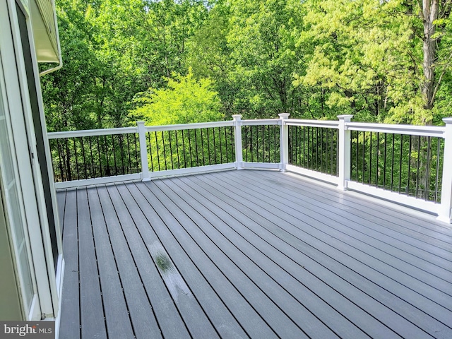 wooden terrace featuring a wooded view