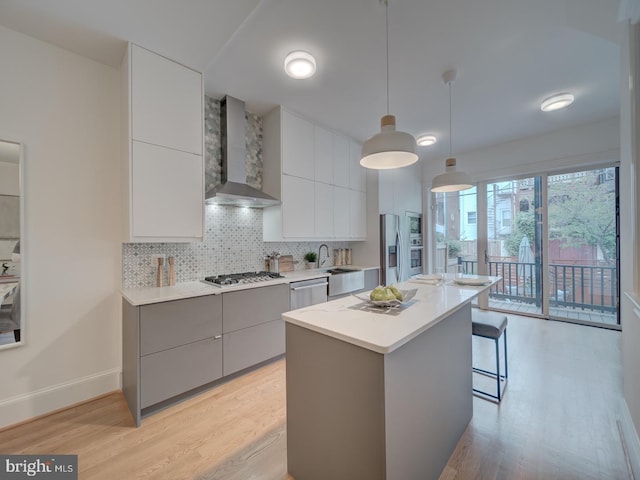 27 Seaton Pl NW, Washington, DC 20001 - kitchen with appliances with stainless steel finishes, modern cabinets, wall chimney range hood, and light wood-type flooring