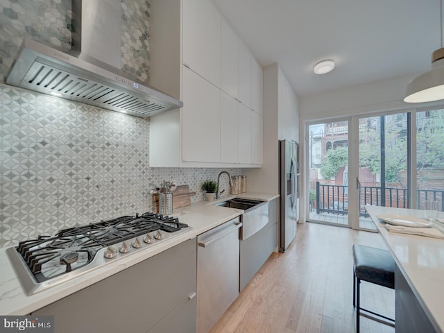 27 Seaton Pl NW, Washington, DC 20001 - kitchen with modern cabinets, wall chimney range hood, light wood-type flooring, light countertops, and appliances with stainless steel finishes