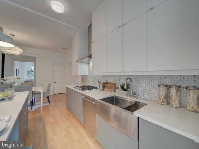 27 Seaton Pl NW, Washington, DC 20001 - kitchen with modern cabinets, tasteful backsplash, a sink, light wood finished floors, and appliances with stainless steel finishes
