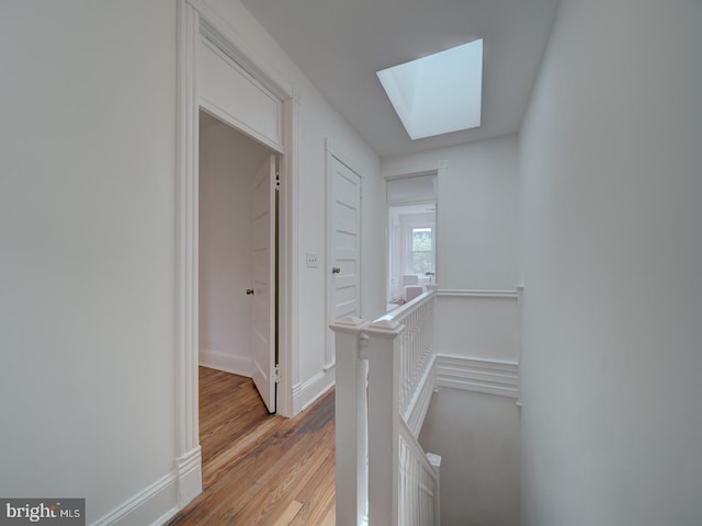 27 Seaton Pl NW, Washington, DC 20001 - hallway with a skylight, baseboards, light wood-style floors, and an upstairs landing