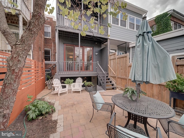 27 Seaton Pl NW, Washington, DC 20001 - back of property featuring a fenced backyard, a patio, brick siding, and a balcony