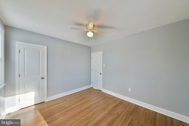 unfurnished room with baseboards, ceiling fan, and wood finished floors