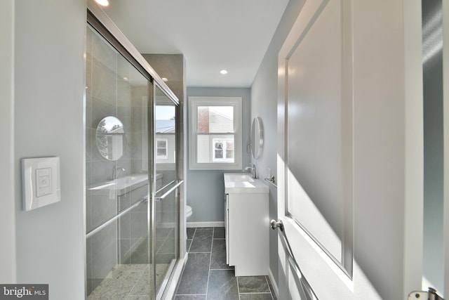 bathroom with vanity, toilet, recessed lighting, baseboards, and a stall shower