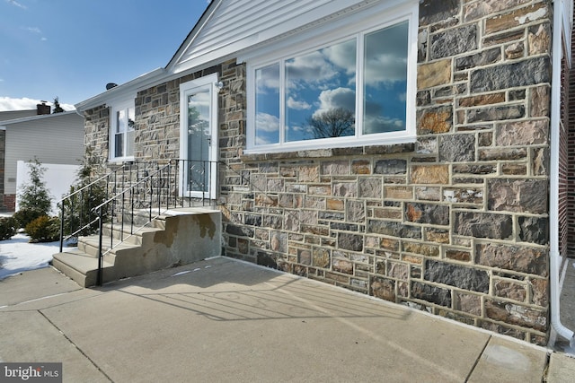 property entrance with stone siding