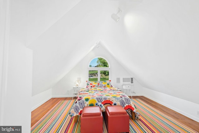 bedroom featuring baseboards, vaulted ceiling, and wood finished floors