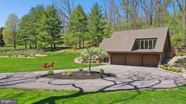 view of front of property with driveway, fence, a front lawn, an attached garage, and stone siding
