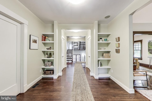 hallway with visible vents, dark wood finished floors, baseboards, and stairway
