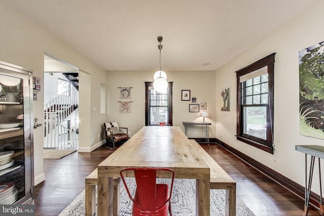 dining space featuring baseboards, stairway, and dark wood-type flooring