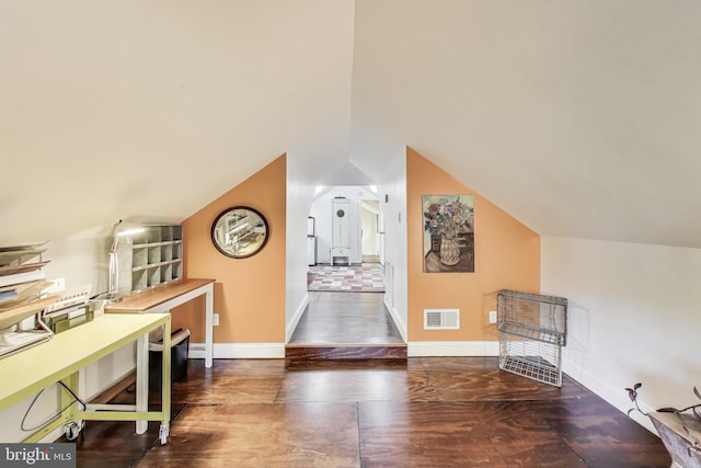 additional living space featuring baseboards, vaulted ceiling, wood finished floors, and visible vents