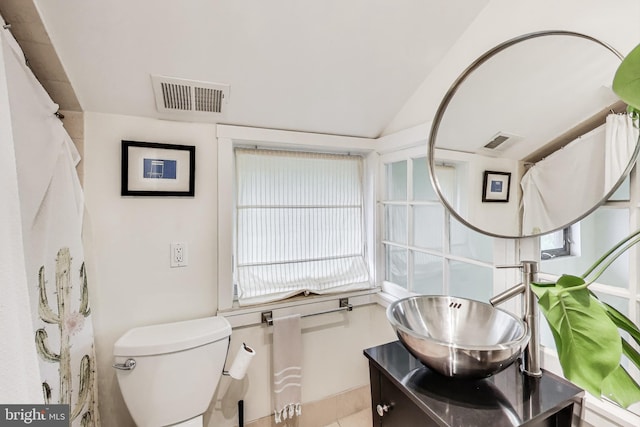 bathroom featuring visible vents, lofted ceiling, toilet, and vanity