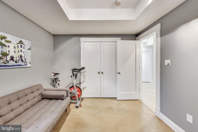 exercise room with a raised ceiling and baseboards