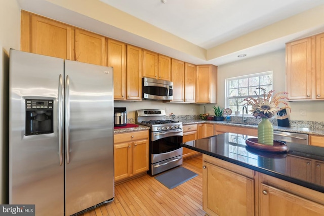 12815 Duck Pond Dr Unit 111, Germantown, MD 20874 - kitchen featuring appliances with stainless steel finishes, a sink, light wood-style flooring, and dark stone countertops