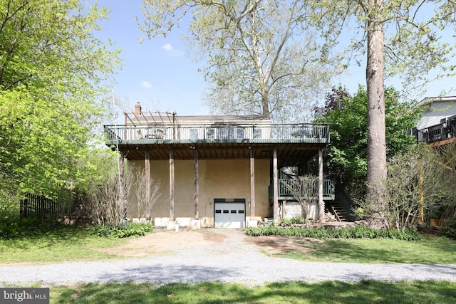 view of outbuilding with a garage, stairs, and driveway