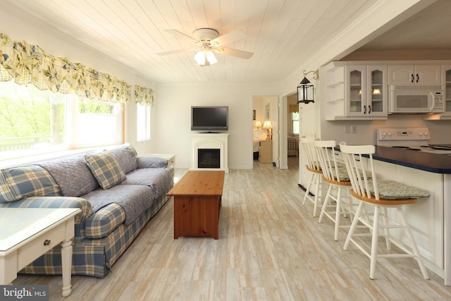 living area with crown molding, light wood finished floors, a fireplace, a ceiling fan, and wood ceiling