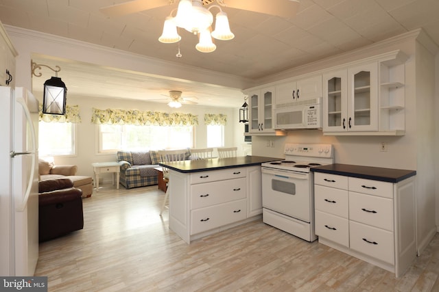 kitchen featuring white appliances, a peninsula, dark countertops, and ceiling fan