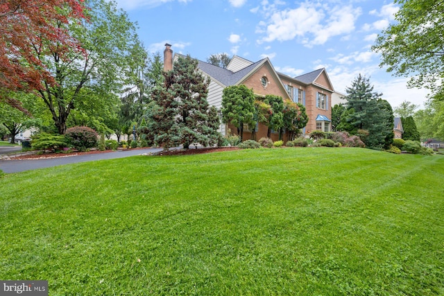 11406 Royal Vw, North Potomac, MD 20878 - view of side of home with a yard, a chimney, brick siding, and driveway