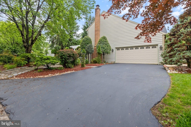 11406 Royal Vw, North Potomac, MD 20878 - view of side of property featuring asphalt driveway, a chimney, and a garage