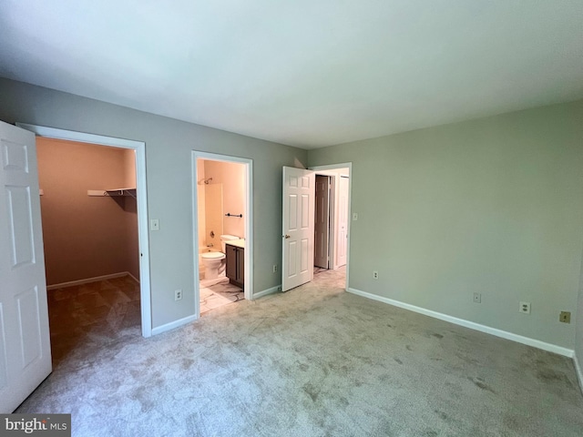 6062 Clay Spur Ct, Centreville, VA 20121 - unfurnished bedroom with a walk in closet, light colored carpet, baseboards, and connected bathroom