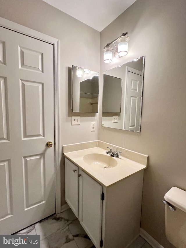 6062 Clay Spur Ct, Centreville, VA 20121 - bathroom featuring toilet, vanity, and marble look tiles