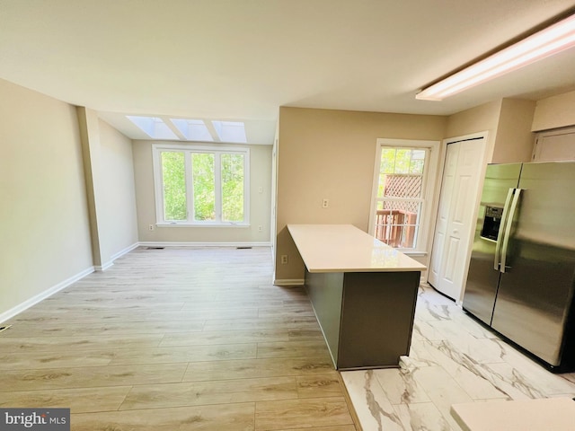 6062 Clay Spur Ct, Centreville, VA 20121 - kitchen with stainless steel fridge with ice dispenser, light countertops, a skylight, and baseboards